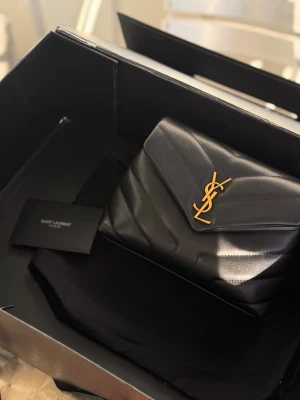 Ysl Loulou toy bag i svart färg  - Helt ny! Allt ingår som kort, dustbag etc. Kartong har jag tyvärr inte kvar då den gick sönder. Så fin väska som passar perfekt till vardags som till fest!