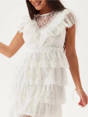 Spets klänning  - Supersöt vit kortklänning med flera lager volanger och spetsdetaljer. Passar till student eller midsommar. Endast använd en gång!!