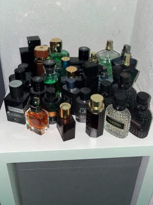 Mix av exklusiva herrparfymer - Samling med flera exklusiva herrparfymer från märken som Valentino, Giorgio Armani och Versace. Flaskorna har olika former och färger, bland annat svart, grönt, genomskinligt och bär detaljer i guld och silver. Perfekt för dig som vill ha variation i din doftgarderob. Tänke kolla intresset alla är inte till salu men skriv och fråga och så kan jag kolla hur mycket det är kvar och ge ett pris👍
