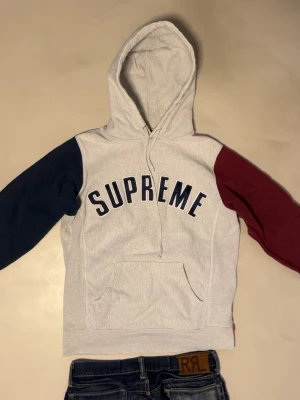 Supreme hoodie  - Säljer denna riktigt snygga Supreme Hoodie. Mestadels grå, blå o röda ärmar, med en stor logga på framsidan. Väldigt unik, säljs ej längre. Storlek M, men passar S också. Skriv vid frågor eller funderingar. Väldigt snabba svar 🙂