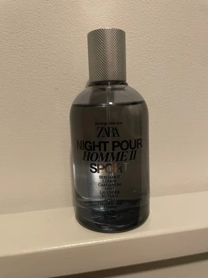 ZARA Night Pour Homme II Sport parfym - ZARA Night Pour Homme II Sport är en parfym i en stilren, mörkgrå glasflaska med silverfärgad metallkork. Doften har inslag av bergamott, citron, kardemumma, mynta, lavendel, muskot, äpple, cederträ, amber, mysk, cassis och elemi. Perfekt för dig som gillar fräscha och kryddiga toner.