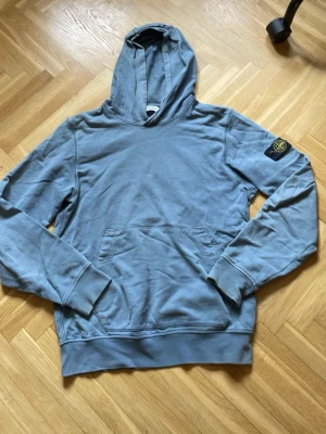 Stone Island Hoodie - Säljer nu denna Stone Island hoodie eftersom den inte kommer till användning. Den är i storleken 170 junior. Den har tecken på slitning såsom armändarna men det skrynkliga går lätt bort med strykjärn!