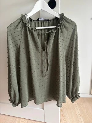 Olivgrön blus med struktur från Zara - Snygg olivgrön blus från Zara med prickig struktur och transparent tyg. Blusen är inte mycket använd och har bra skick