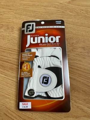 Vit golfhandske FootJoy Junior Large - Snygg vit golfhandske från FootJoy i juniorstorlek Large. Handsken har svarta detaljer och ett tydligt FootJoy-märke på kardborrebandet. Perfekt för dig som vill ha bra grepp och stil på golfbanan. Oanvända. Skriv gärna vid funderingar. Mvh!!