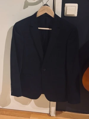 Mörkblå kavaj - Stilren mörkblå kavaj med slim passform. Pris går att förhandla. Fint skick!