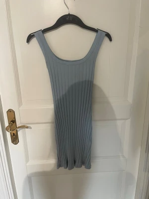 Ljusblå ribbad kortklänning - Säljer en ljusblå ribbad kortklänning. Toppen är ärmlös med breda axelband och har en stretchig, figurnära passform.