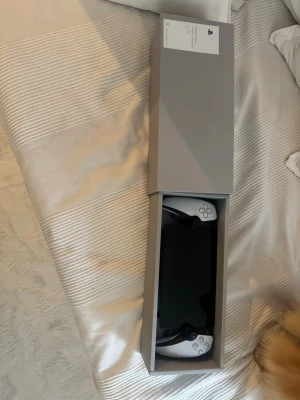 PlayStation Portal  - Säljer en PlayStation Portal Remote Player från Sony. Handhållen spelkonsol i  vitt med inbyggd skärm och kontroller på sidorna, perfekt för att streama PS5-spel trådlöst. Modern design i plast med klassiska PlayStation-knappar.