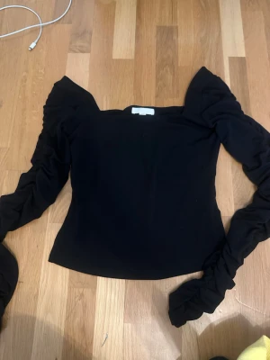 Svart topp med puffärmar - Trendig svart topp med långa puffärmar..