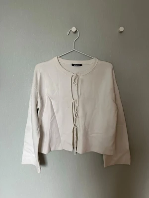 Vit kofta med knytning framtill - Vit kofta med knyt framtill från GinaTricot! Skrynklig på bilden men skickad struken. Har en liten blå fläck på högra underarmen, men annars i fint skick’