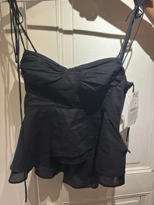 Svart topp med tunna axelband från Zara - Aldrig använd, dock sprucken vid sidan när jag testade den. Prislappen är kvar.  Väldigt liten i storlek jag är en M men den är liten. 💕 