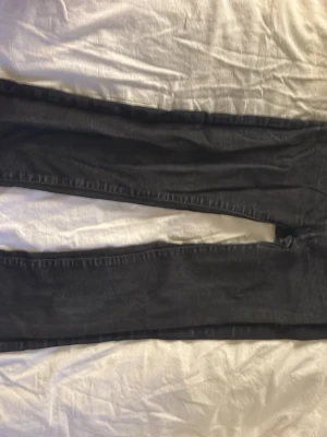 Svarta bootcut jeans från Cubus - Säljer ett par svarta bootcut jeans från Cubus. Jeansen har klassisk femficksmodell, knapp med logga och smal passform upptill, vid passform nedtill. Materialet är stretchigt denim som sitter snyggt och bekvämt. Perfekta till alla typer av outfits!