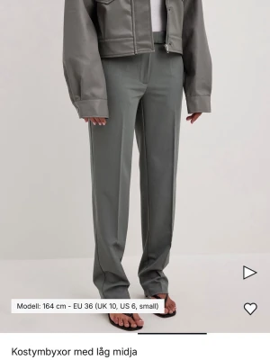 Grå kostymbyxor med låg midja - Stilrena grå kostymbyxor med låg midja och raka ben. Aldrig använda. 