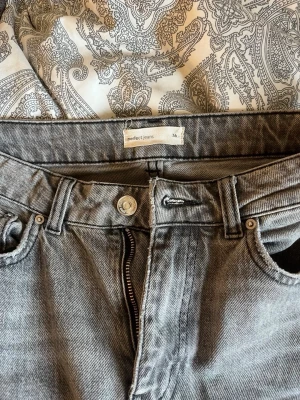 Grå jeans från Perfect Jeans - Säljer ett par grå jeans från Perfect Jeans i storlek 34. Jeansen har klassisk femficksdesign, raka ben och är tillverkade i denim. De har en snygg, lite tvättad look och passar perfekt till en avslappnad stil.