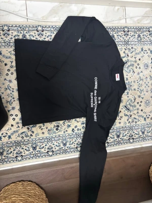 Comme des Garçons x Supreme Longsleeve - Svart CDG x Supreme longsleeve. Använd 1 gång, nyskick. Clean tryck på ärmen. Storlek L men jag säger att den passar S-M