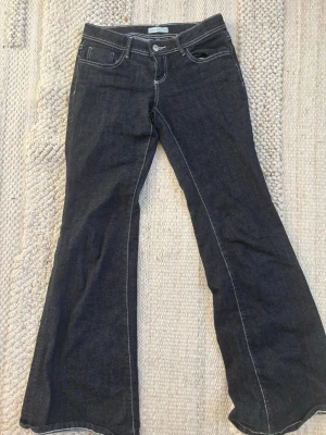 Mörkblå bootcut jeans från Gina tricot  - Snygga mörkblå bootcut jeans med vita kontrastsömmar från Gina tricot. Säljer för att jag råkade köpa en storlek för stor så dem är knappt använda och i bra skick. Tveka inte på att höra av er om ni har någon fråga!