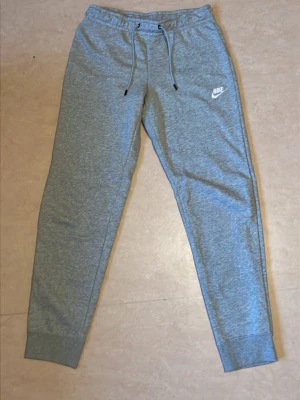 NIKE , mjukis byxor M - HELT OANVÄNDA MJUKISBYXOR. Nya gråa mjukis byxor från Nike i storlek M.
