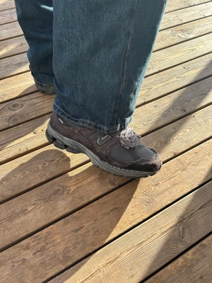 Gråa New Balance 2002r sneakers - Snygga gråa New Balance 2002r sneakers med mesh och mockadetaljer. Skorna har klassisk N-logga på sidan, robust sula och sköna snörningar. Perfekta för dig som gillar streetwear och sportig stil.