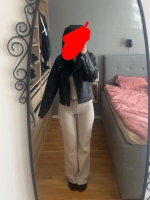 Svart skinnjacka med dragkedja - Säljer en svart skinnjacka i klassisk bikerstil med sned dragkedja och breda slag. Jackan har silverfärgade detaljer och en kort, figurnära passform som ger en cool look. Perfekt att slänga över en hoodie eller t-shirt för en edgy vibe.