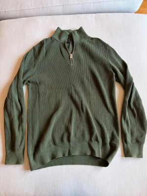 Grön stickad half zip - En mörkgrön stickad tröja med half zip. Använd men i fint skick. Från H&M