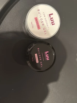 Luu Builder Gel Perfect Pink & Milky Pink - Två burkar Luu Professional Builder Gel för naglar, en i färgen Perfect Pink och en i Milky Pink. Gelen har låg viskositet och kommer i runda plastburkar om 30g. Perfekt för att bygga och forma snygga naglar med naturlig finish.