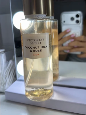 Victoria's Secret Coconut Milk & Rose - Fräsch body mist från Victoria's Secret med doft av kokosmjölk och ros. Flaskan är genomskinlig med guldigt lock och rymmer 250 ml. Perfekt för dig som gillar mjuka, blommiga och krämiga dofter.