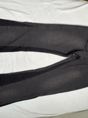 Svarta jeans - Snygga svarta jeans med smal passform och klassisk femficksdesign. Jeansen har en enkel look utan synliga slitningar eller dekorationer. Perfekta till en avslappnad stil och passar till det mesta. Materialet ser ut att vara bomull med stretch. Storlek passar S