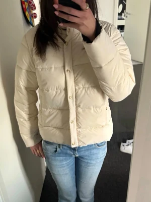 Vårjacka - Superfin vårjacka från Zara. Använd ett fåtal gånger men annars i nyskick. Krämvit/beige med guldiga knappar och detaljer.