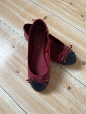 Vinröda ballerinaskor från Primark - Snygga vinröda ballerinaskor från Primark med svart tå och dekorativ rosett framtill. Skorna har en klassisk rundad form och är tillverkade i textilmaterial. Perfekta för dig som gillar stilrena och trendiga skor med en liten twist. Det står att storleken är för 37 men jag säljer dem för att dem va för små så dem passar dem som har 36 i sko storlek. 