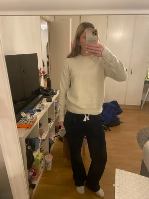 Beige stickad tröja med rund hals - En enkel och stilren beige stickad tröja med rund hals och ribbade muddar. Tröjan har en rak passform och långa ärmar, perfekt för att hålla sig varm under kyliga dagar. Materialet känns mjukt och bekvämt mot huden.