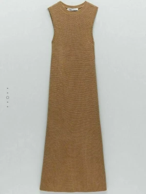 Beige stickad ärmlös klänning Zara - Säljer en beige stickad klänning från Zara. Klänningen är ärmlös med rund halsringning och har en rak, lätt utställd passform. Materialet är grovstickat och ger en mysig känsla. Perfekt att styla med boots eller sneakers för en trendig look.