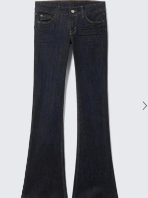 Mörkblå bootcut jeans från Cheap Monday - Snygga mörkblå bootcut jeans från Cheap Monday med klassisk femficksmodell och lila logga bak. Jeansen har utsvängda ben och kontrastsömmar. Tillverkade i stretchig denim för skön passform. Använd en gång! Så helt nya. Storlek 29/34