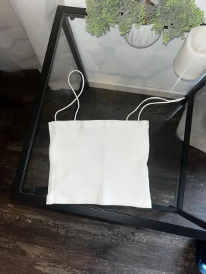 Vit ribbad tubtopp från Zara - Vit ribbad tubtopp från Zara med smala axelband. Enkel och stilren design som passar perfekt till sommaren. Mjuk och stretchig känsla, lätt att matcha med olika outfits.