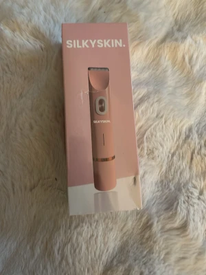 SilkySkin elektrisk rakapparat rosa - Snygg elektrisk rakapparat från SilkySkin i en stilren rosa färg. Designad i Sverige med minimalistisk look och smart funktion för silkeslena resultat. Perfekt för dig som vill ha en smidig och effektiv hårborttagning. Kommer i originalförpackning. Kartongen är lite trasig men den är helt oöppnad och plasten är kvar