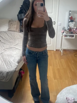 Blå jeans med broderade vingar - Säljer ett par blå jeans med broderade vingar och pärlor på bakfickorna. Jeansen har en klassisk femficksdesign, raka ben och normal midja. Perfekta för dig som vill ha något unikt och snyggt i garderoben.