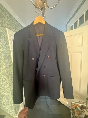 Mörkblå dubbelknäppt kavaj - Tiger of Sweden  - Dubbelbröstad kavaj från Tiger of Sweden. Mörkblå med bruna knappar. Använd en gång i storlek 52