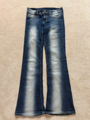 Blå jeans från Weekday - Snygga blå jeans med ljusa slitningar på framsidan och klassisk femficksdesign. Jeansen har knapp och dragkedja framtill samt bälteshällor. Perfekt för dig som gillar en cool och avslappnad look. Strl 27/32 men skulle även kunna passa 26