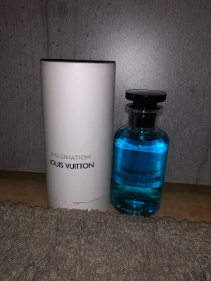Louis Vuitton Imagination parfym - Lyxig parfym från Louis Vuitton, Imagination, med fräsch blå vätska i en stilren, och magnetisk kork för att vissa äkthet. Har även rund glasflaska med svart spraykork. Kommer med elegant vit förpackning. Perfekt för dig som vill ha en exklusiv doft i samlingen.