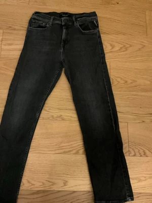 Svarta Replay jeans med raka ben - Säljer ett par svarta jeans från Replay med raka ben och klassisk femficksmodell. Jeansen har en snygg tvätt som ger en cool look. Perfekta till vardags för dig som gillar en avslappnad men stilren stil.