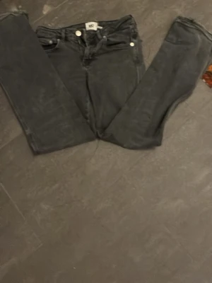 Svarta 90's bootcut jeans från 157 - Säljer ett par svarta bootcut jeans från 157 med klassisk 90-talsvibe. Jeansen har fem fickor, bälteshällor och knappgylf. Materialet är denim och passformen är något utsvängd nedtill för en retro look.