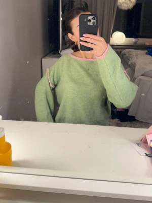 Grön stickad tröja med rosa detaljer - Super fin tröja som tyvärr inte kommer till användning. Perfekt för sommar/vår. Ifrån design by si! 