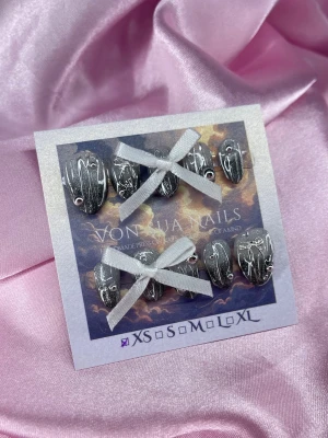 Kuro (XS);Short Almond - Unika handgjorda press-on naglar i metallic silver med handmålat 3D mönster och silver pärlor. Naglarna har en kort mandel form och finns i XS: 14 mm, 11 mm, 11,5 mm, 10 mm, 8 mm . Perfekt för dig som vill ha en edgy och kreativ look.