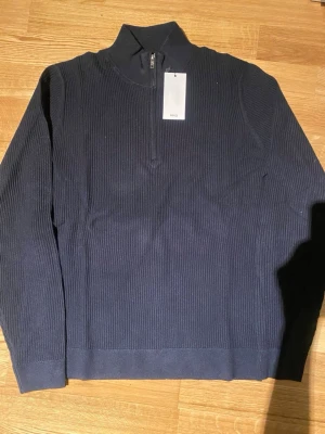 Mörkblå stickad tröja med halv dragkedja - Mörkblå stickad tröja från Mango, halv dragkedja vid halsen. 