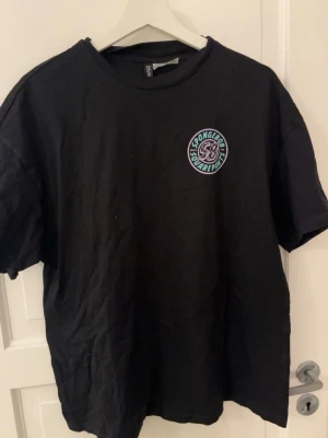 Svart Spongebob t-shirt med tryck - Svart t-shirt från Divided med Spongebob Squarepants-tryck på bröstet och stort motiv på ryggen med Spongebob och Patrick samt texten 'Keep the good vibes flowing'. Skön passform och cool design, perfekt för dig som gillar tecknade serier.