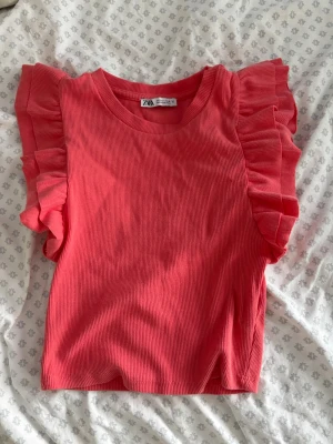 Rosa ribbad topp med volangärmar Zara - Supersöt rosa ribbad topp från Zara med volangdetaljer på axlarna. Perfekt för dig som vill ha en trendig och färgglad look till sommaren.💗☀️