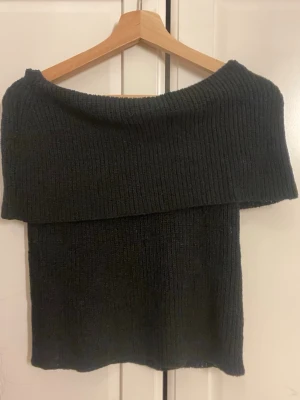 Svart off shoulder stickad topp Nelly - Säljer en svart ribbstickad off shoulder topp från Nelly. Helt oanvänd men utan lapp