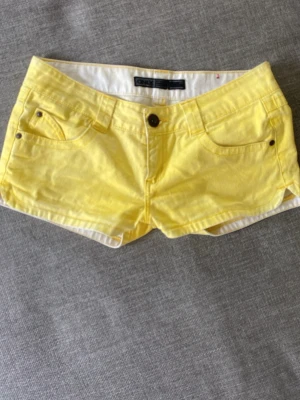 Gula denimshorts från Only - Snygga gula shorts från Only i klassisk denimstil. Modellen har låg midja, fem fickor och stängs med knapp och dragkedja. Perfekta för varma sommardagar och ger en fräsch pop av färg till din outfit. Säljer för att jag köpte dem second hand men de var för stora☹️jätte snygga!!