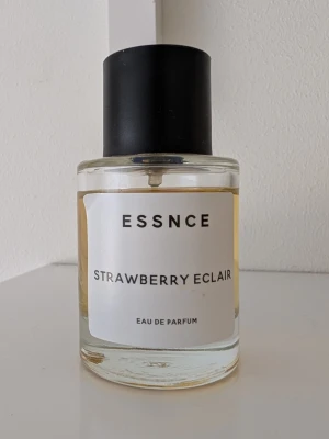 ESSNCE Strawberry Eclair parfym - OBS jag kan fixa fri frakt, kontakta mig innan köp. 💜En parfym från ESSNCE med doften Strawberry Eclair. Flaskan är cylindrisk i genomskinligt glas med svart matt kork och vit etikett med svart text. Innehållet har en ljusgul ton. Eau de Parfum som ger en söt och fruktig känsla. 