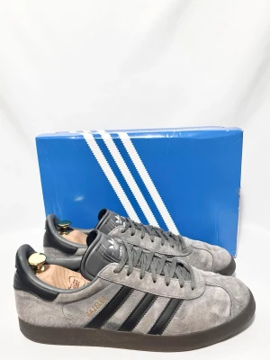Addidas Gazelle Sneakers i mocka - Addidas Gazelle sneakers i en riktigt fet modell med grå mocka och brun sula! Använda men fortfarande i väldigt fint skick, inga tydliga defekter. Alla tillbehör ingår. Storlek 44,5. Kontakta mig för fler frågor och funderingar!