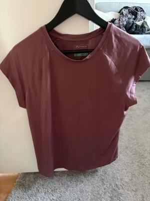 Träningströja  - En lilaaktig träningstshirt i träningsmaterial. Inga tecken på användning. 