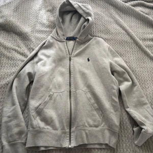  Grå Ralph Lauren Hoodie - Tjena! Säljer nu denna ralph lauren hoodien som blivit för liten. Storlek: M men passar S också. Den är i 8/10 skick, finns dock inga snören. Vid fler frågor eller bilder så är de bara att skriva! 